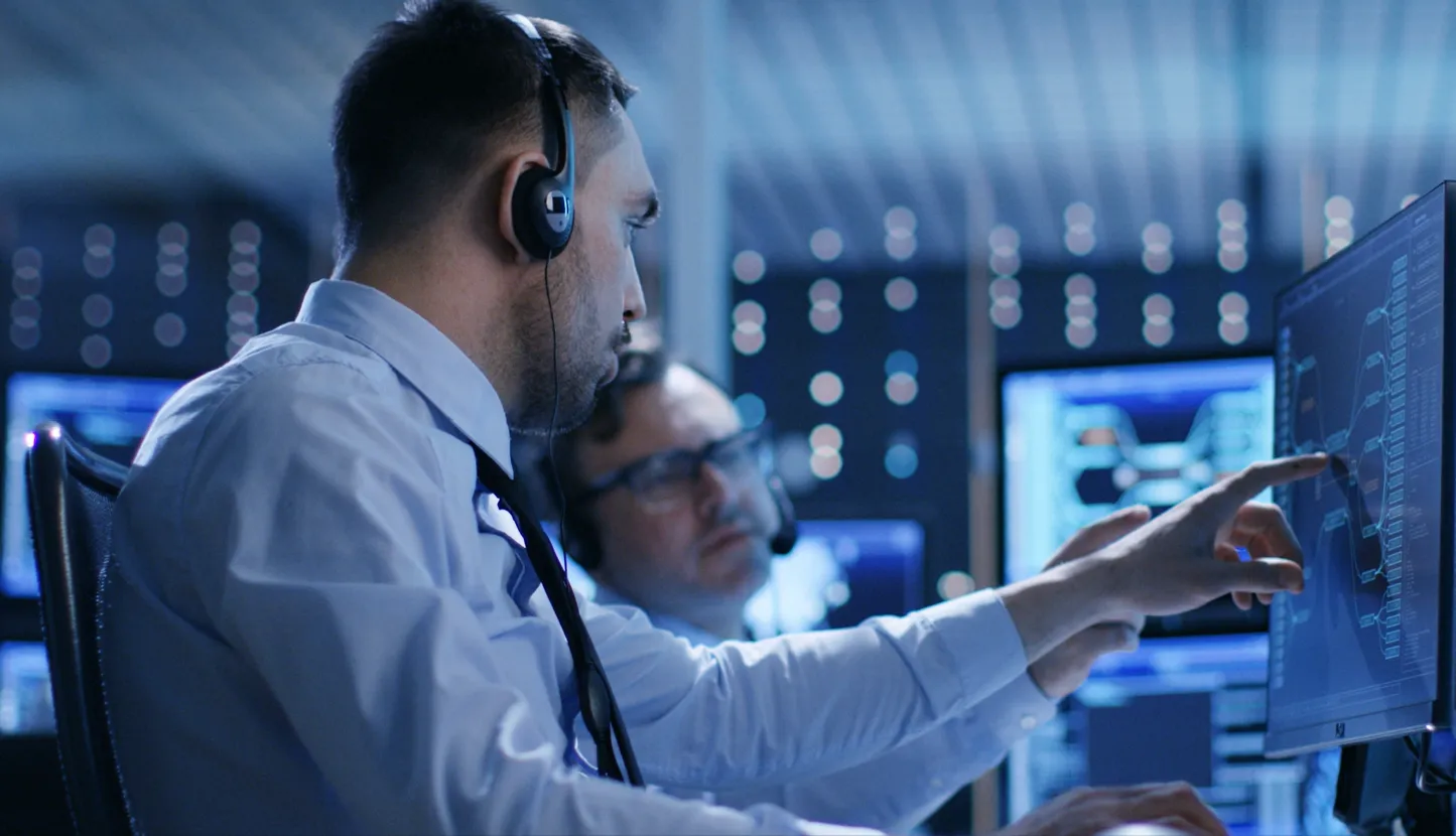 IT engineers monitoring systems on multiple screens in an operations centre