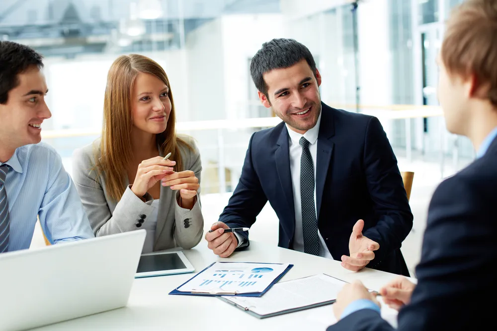Business team smiling in a meeting around a table