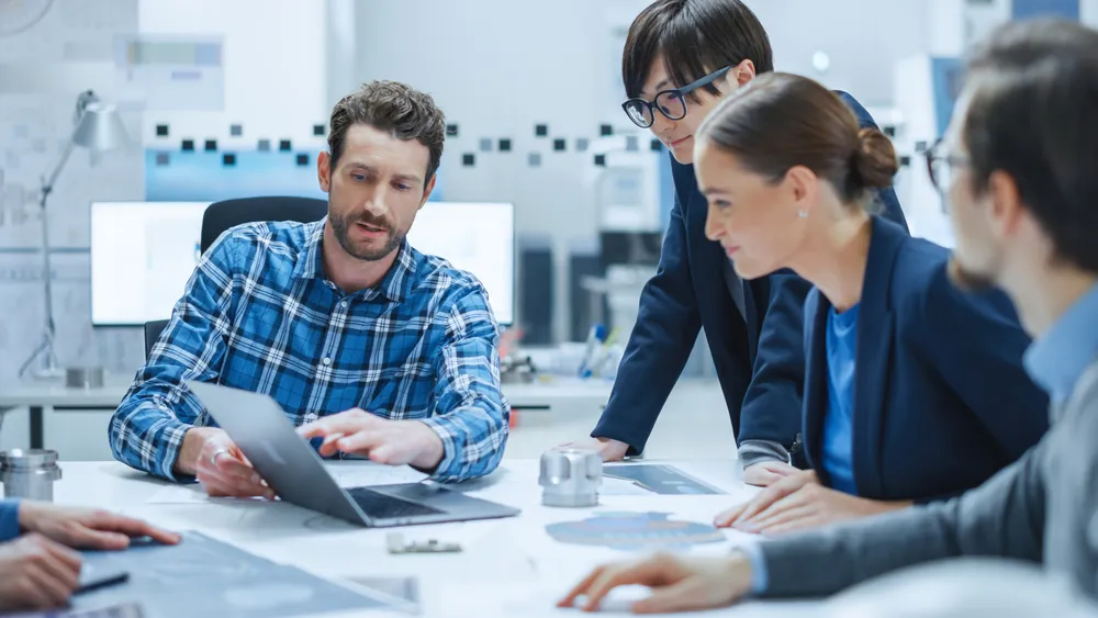 IT technicians working together on a laptop in an office