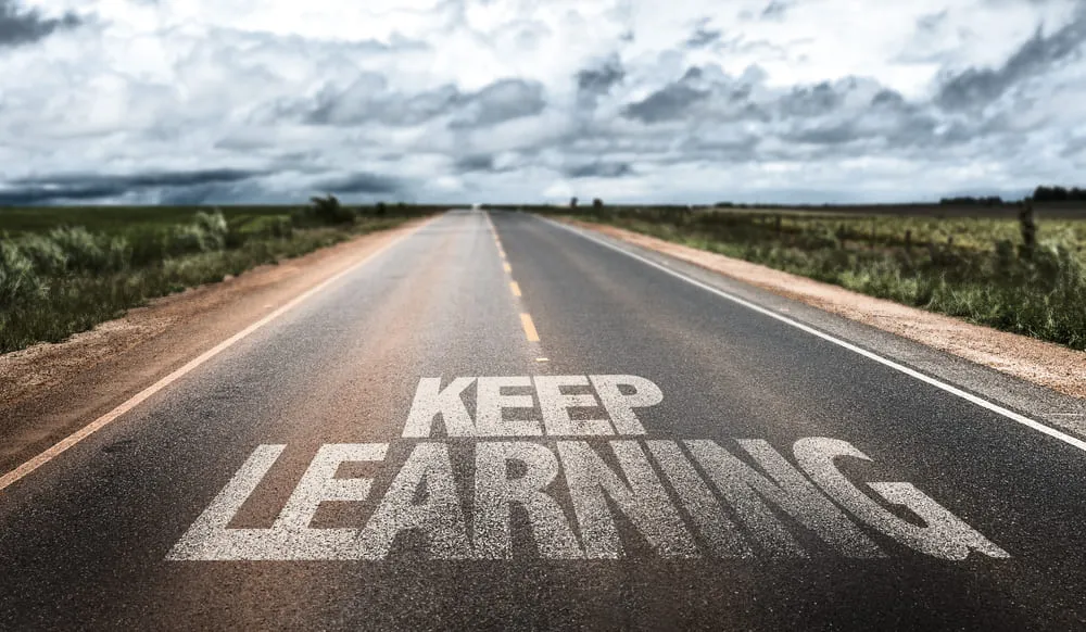 Road with the words Keep Learning painted on it